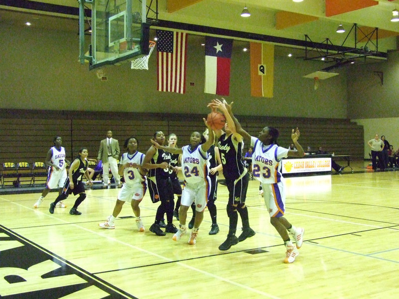 Image: DeMoss Gets Entangled — DeMoss tries to rip the ball from the clutches of two Gators.