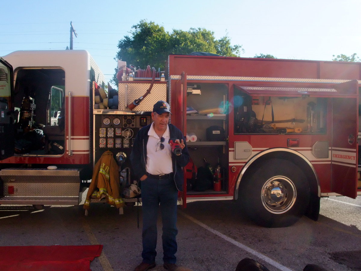 Image: Chief Chambers with Camera — Fire Chief Don Chambers was showing the students a camera that can detect smoke inside walls.