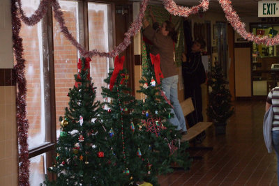 Image: Clover Stiles reaches high — Mrs. Stiles puts the finishing touches on Christmas Tree Blvd.