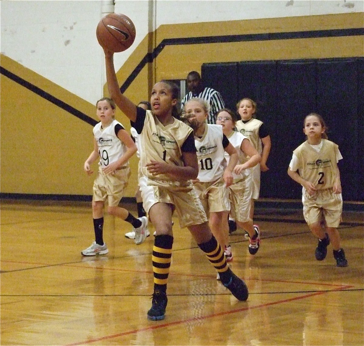 Image: Chasing the ball — Emily Cunningham(1) tracks the loose ball during the battle between Italy 13 (Gold) and Italy 14 (White) in the 3rd &amp; 4th grade girls division.