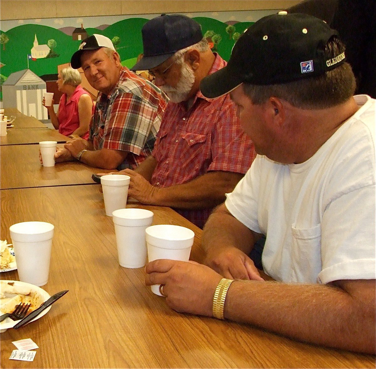 Image: How ’bout those Gladiators? — Richard Cook, Ronnie Compton and Brian Mathiowetz enjoy visiting after their meal.