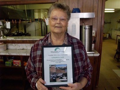 Image: Thank You Doris Mitchell — Doris Mitchell, owner of the Uptown Cafe, accepts a framed, "Thank you,” for the Uptown Cafe’s participation in Monolithic’s food waste drive to test a specialized compost cover.