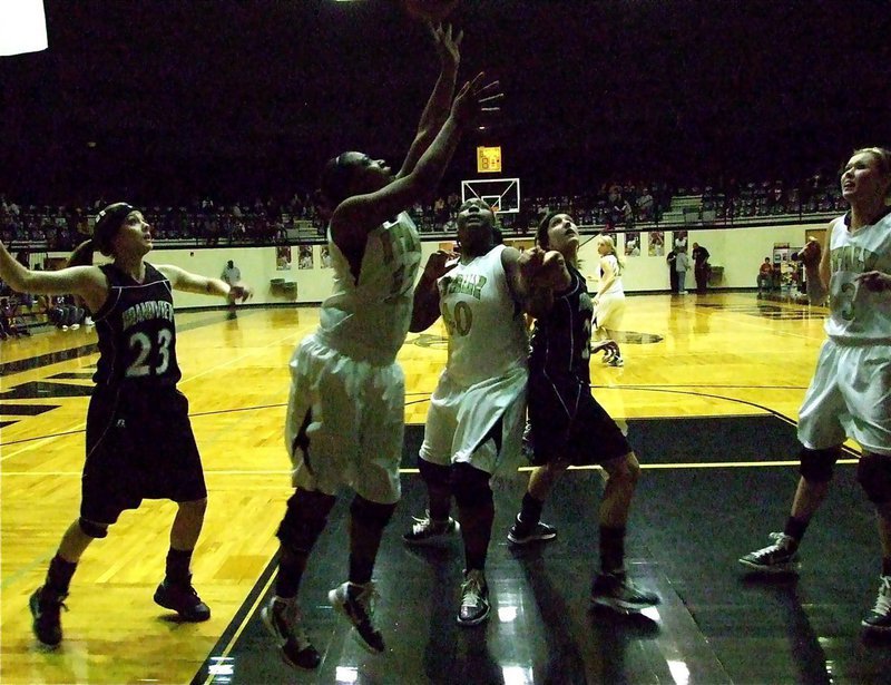 Image: Points in the paint — Lady Gladiator Chante Birdsong(12) drives the baseline as teammates Jimesha Reed(40) and Kaitlyn Rossa(3) battle for position.