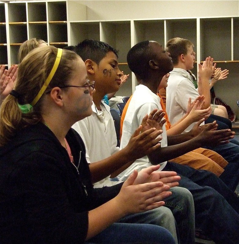 Image: Hands need tuning — Members of the 6th grade band clap their hands to substitute for instruments they don’t have.