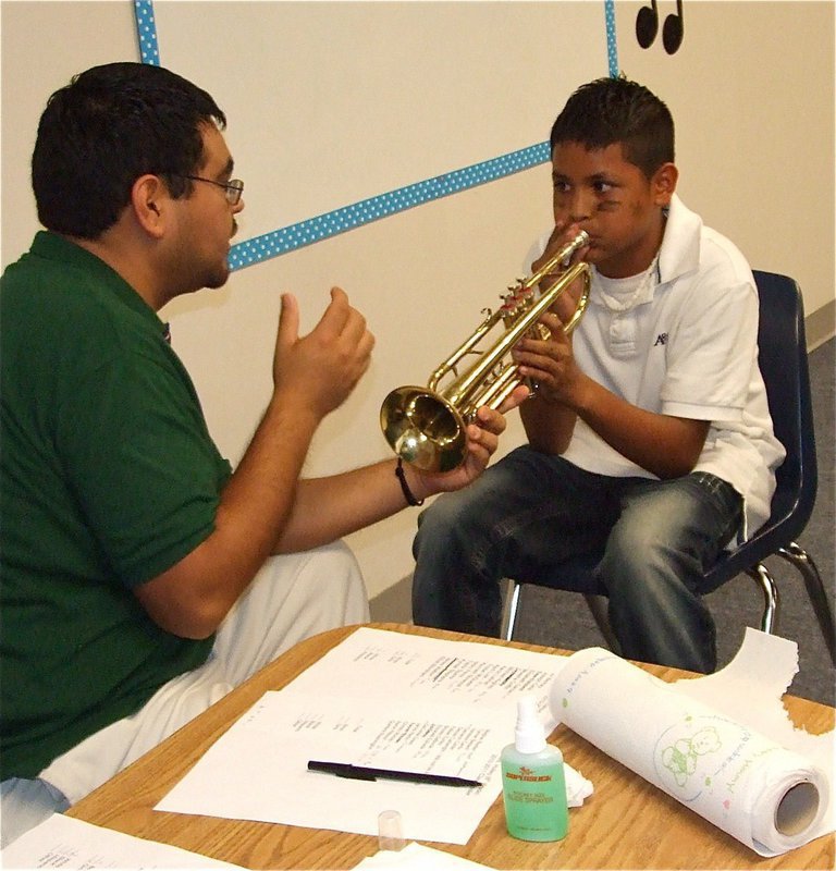 Image: Blow high and low — Jesus Perez helps match 6th grade band members select an instrument best suited for their individual talents.