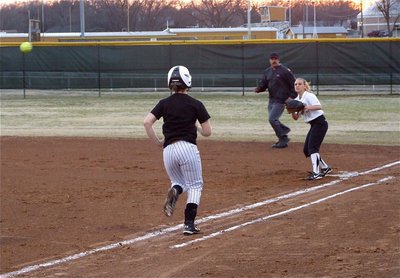 Image: I have your back! — Second baseman Mary Tate(5) covers first for first baseman Bailey Bumpus who makes the throw for the out.