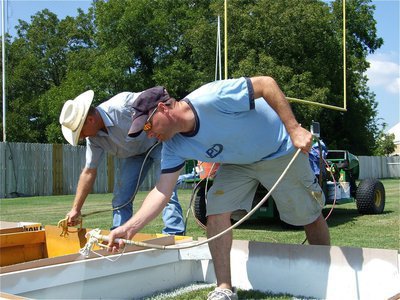 Image: Together we can — Italy ISD School Board members Curtis Riddle sprays a gold square and Paul Cockerham fills in a white square.