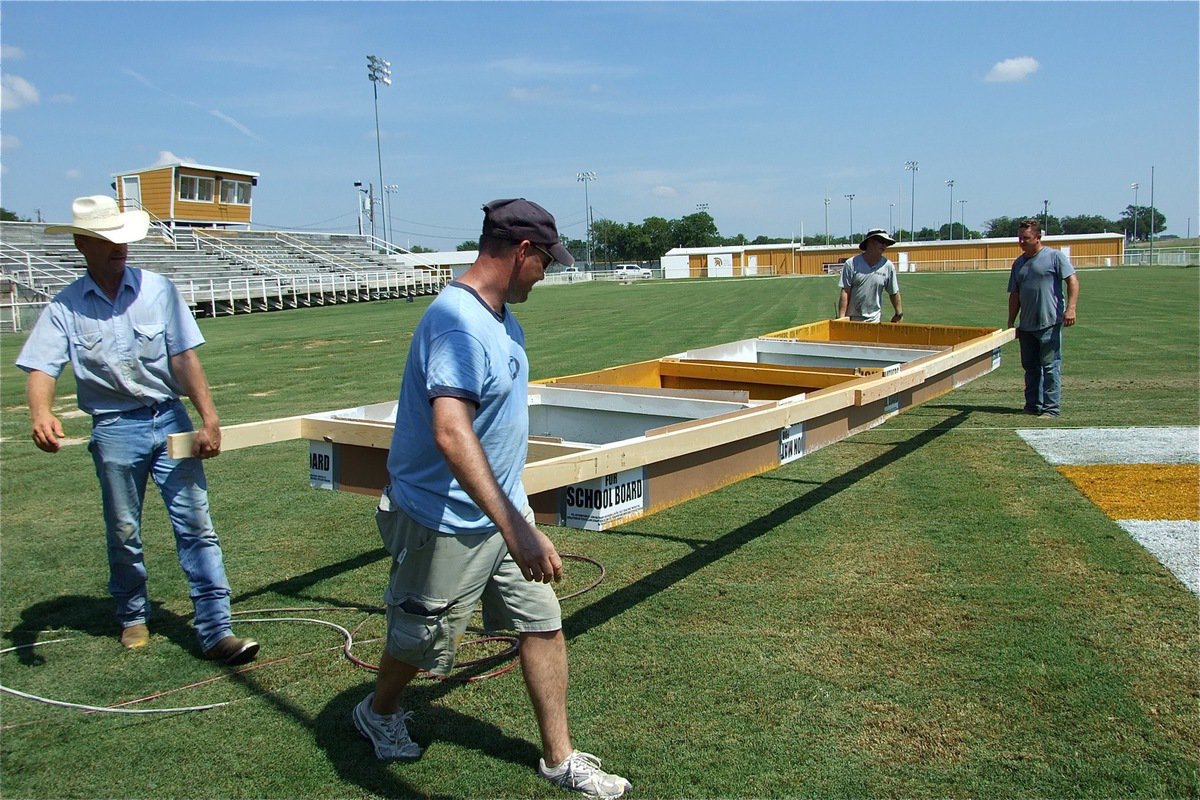 Image: Getting heavy — As the painting continues, the wooden frame gets heavier and heavier requiring all four to rotate the frame.