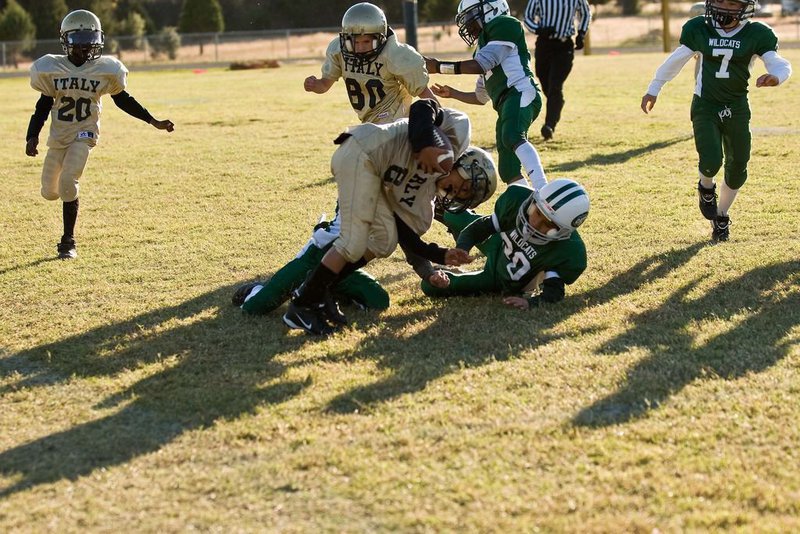 Image: Heading For Daylight — 2 – Tylan Wallace tries to keep his feet while he heads for yardage against Wildcat defenders.