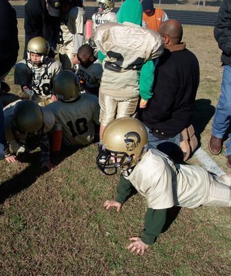 Image: Football Weather — Corbin Schrotke relies on push-ups trying to stay warm during the halftime of the C Division’s Conference Championship game between Italy and Scurry.