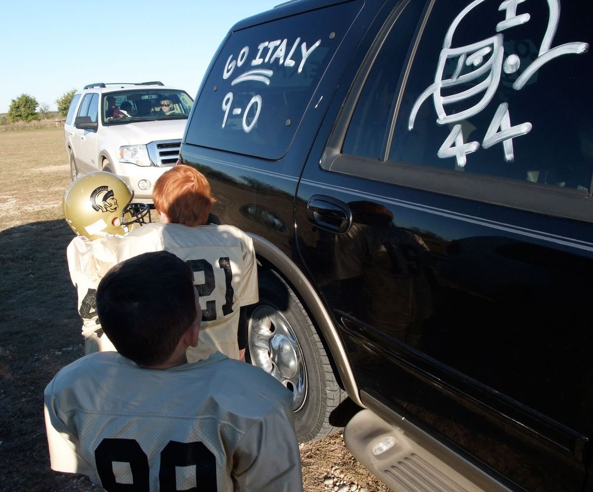 Image: Check It Out! — Bryce DeBorde, Levi Stark and Mason Griffin admire the shoe polish wishing them luck in the game against Scurry.