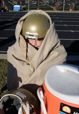 Image: BBBBUUUUURRRRRR — Mason Griffin peeks through the blanket, he’s using to stay warm, before the game against Scurry.