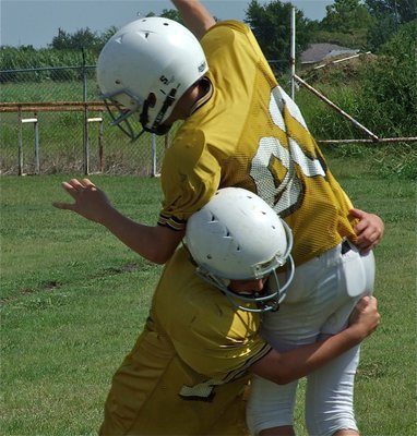 Image: Cousins collide — Brandon Connor gives his quarterbacking cousin Ryan Connor a love tap.