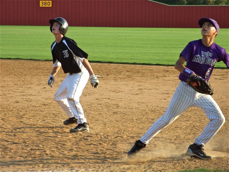 Image: In the air — Italy’s Trevor Patterson watches the ball and holds at first base while Waco’s defense tears after the popup.