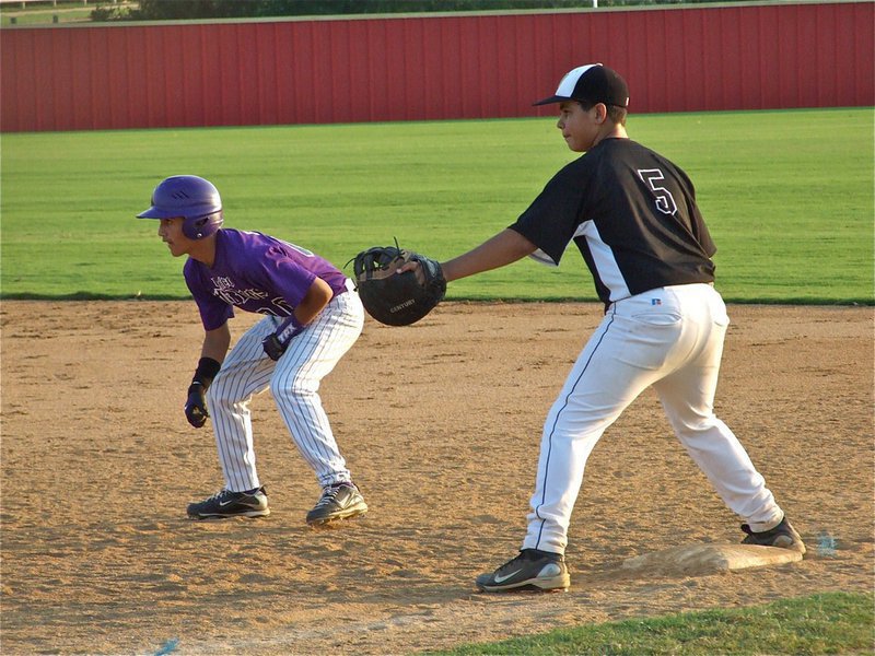 Image: Who’s on first? — Italy’s Reid Jacinto(5) holds a Mud Dogs’ player on first base.