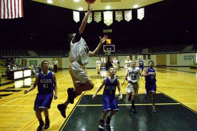 Image: Up and away — Chace McGinnis(32) flies high to finish the fast break.