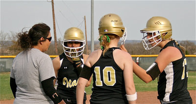 Image: A little encouragement — Lady Gladiators’ assistant coach Tina Richards stops play at third base to talk strategy with Anna Viers(3), Paige Westbrook(10) and Megan RIchards(17).