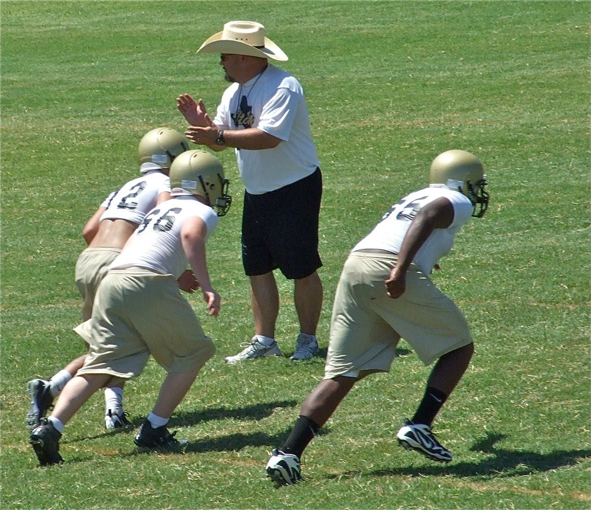 Image: Bales lends a hand — Head Coach Craig Bales motivates the players during conditioning drills.