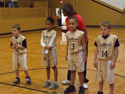 Image: Just add basketball — Bryce DeBorde(4), Destiny Harris(1), Cornelius Jones(3) and Reese Janek(14) prepare to start the game as head coach Deloris Harris gives them last second pointers.