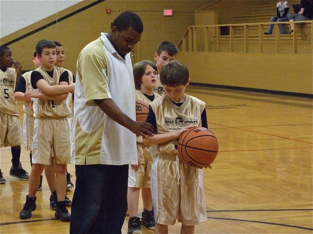 Image: Coach helps out — Coach Edwin Wallace helps Steven Davis(33) with his free throw stance.