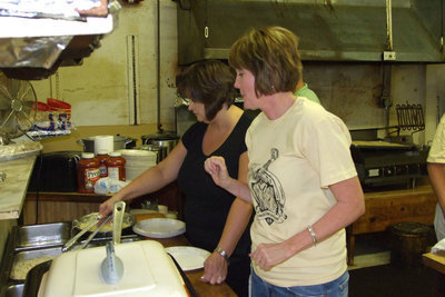 Image: Band Booster Parents — Susan Jacinto and Penny Rossa help serve plates.