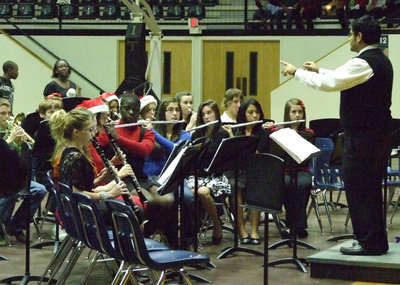 Image: Instruments up — IHS Band Director, Jesus Perez, readys his 7th grade band.