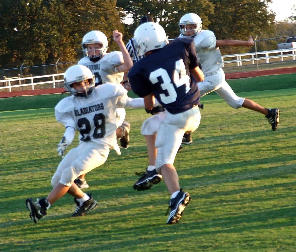 Image: Pass! — Levi McBride(28), Cody Boyd(22) and Colton Petrey(6) jump out into pass coverage.