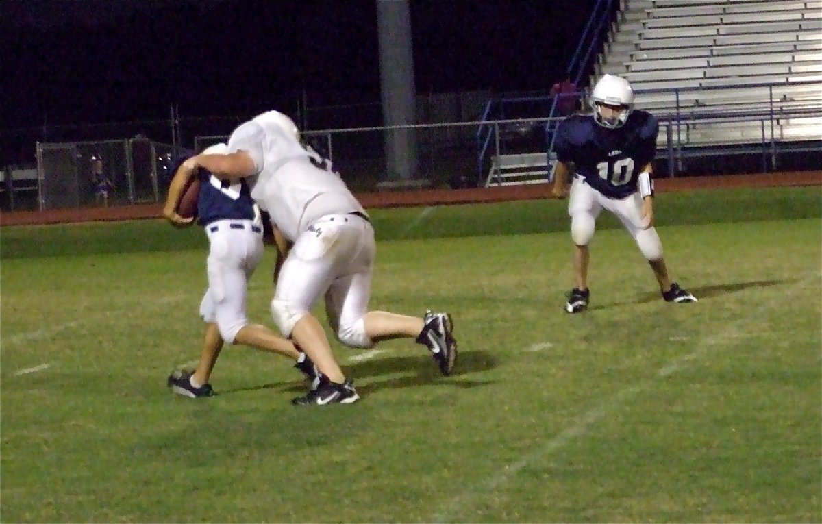 Image: Tackle for a loss — John Byers(56) captures a Cougar runner in the backfield for a 10-yard loss.