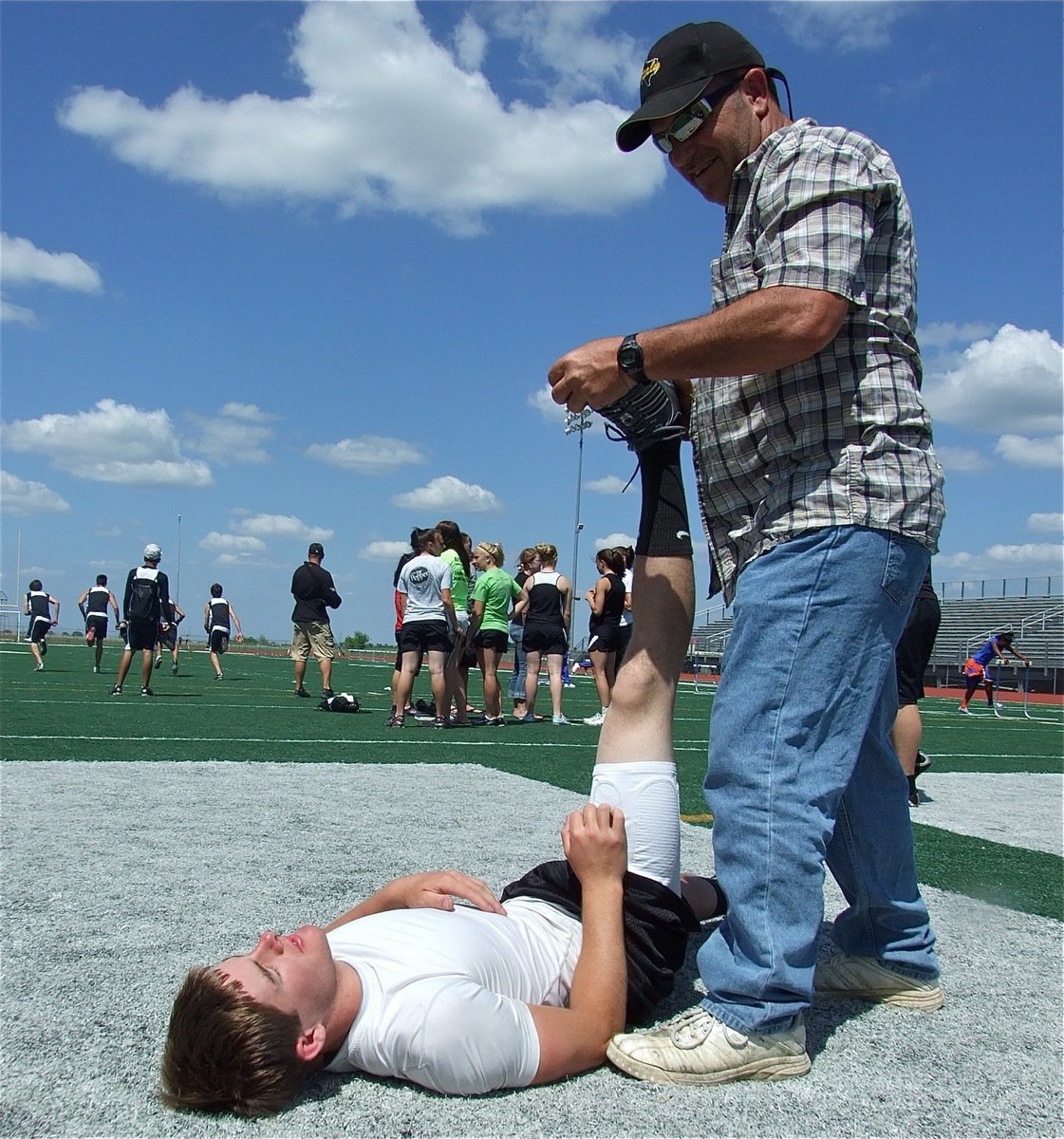 Image: Past and present — Former Gladiator track star Lee Hamilton helps Ryan Ashcraft stretch out. Mr. Hamilton knows his stuff, helping Ashcraft to finish in 2nd Place.