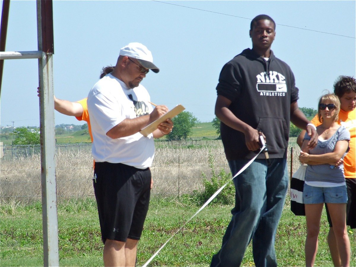 Image: Helping out — Coach Craig Bales and Larry Mayberry handle the measuring duties at the shot put.