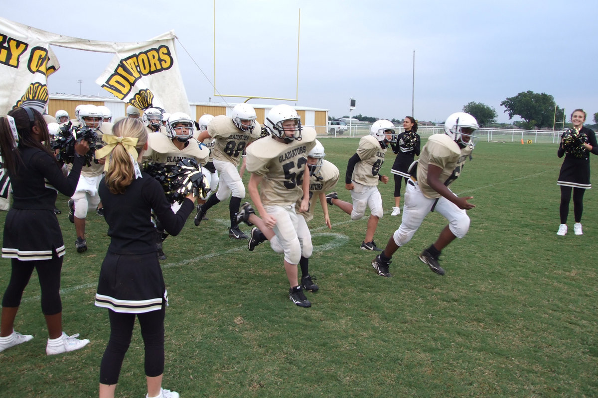 Image: Ready to rumble — IHS 8th grade team tears through the sign ready to play.