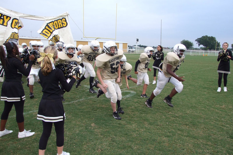 Image: Ready to rumble — IHS 8th grade team tears through the sign ready to play.