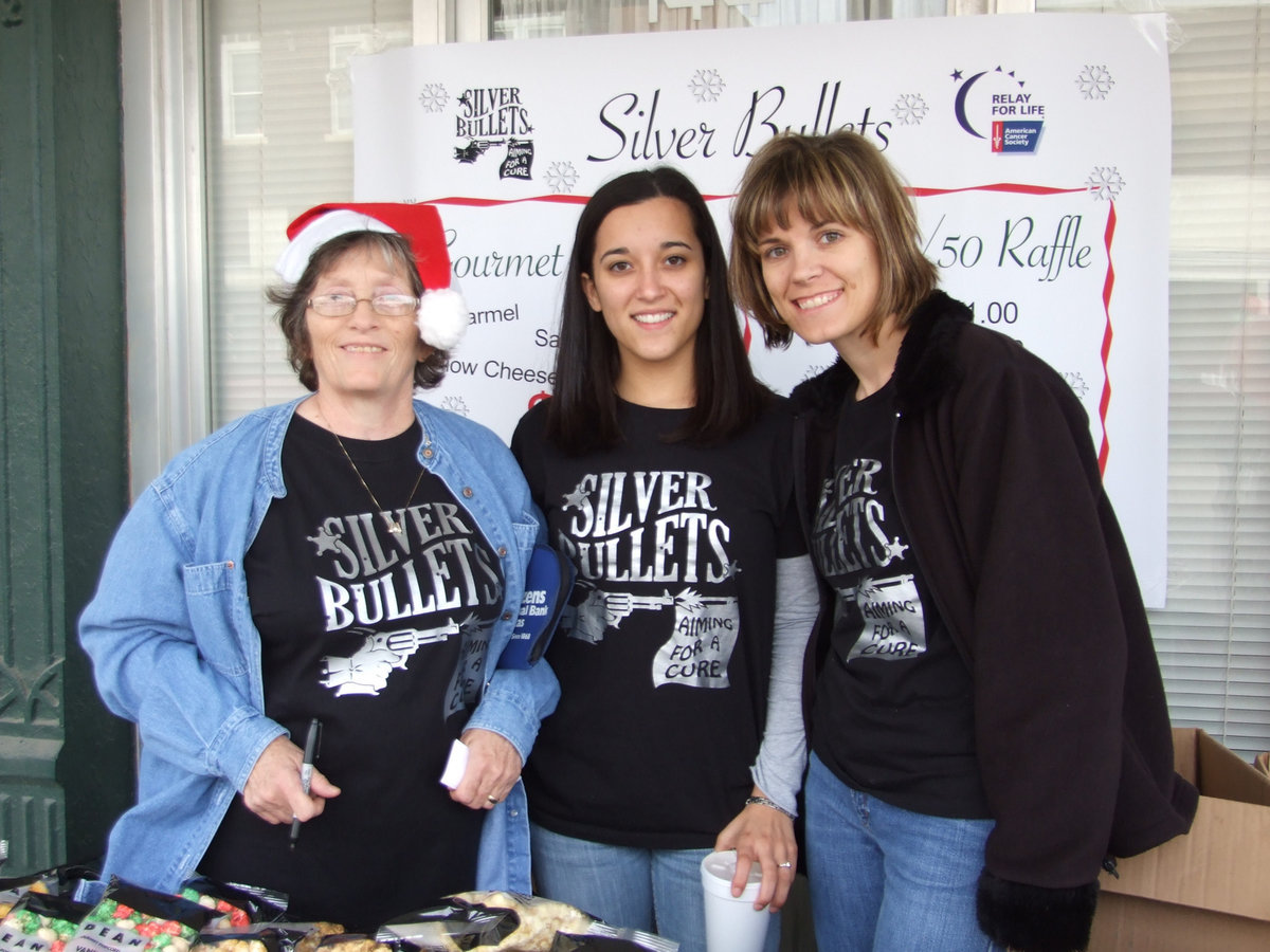 Image: Silver Bullets Relay Team — Three members of the Silver Bullets Relay Team sell popcorn to earn money to help the fight against cancer.