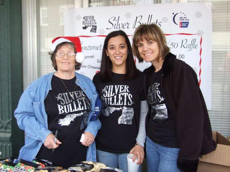 Image: Silver Bullets Relay Team — Three members of the Silver Bullets Relay Team sell popcorn to earn money to help the fight against cancer.