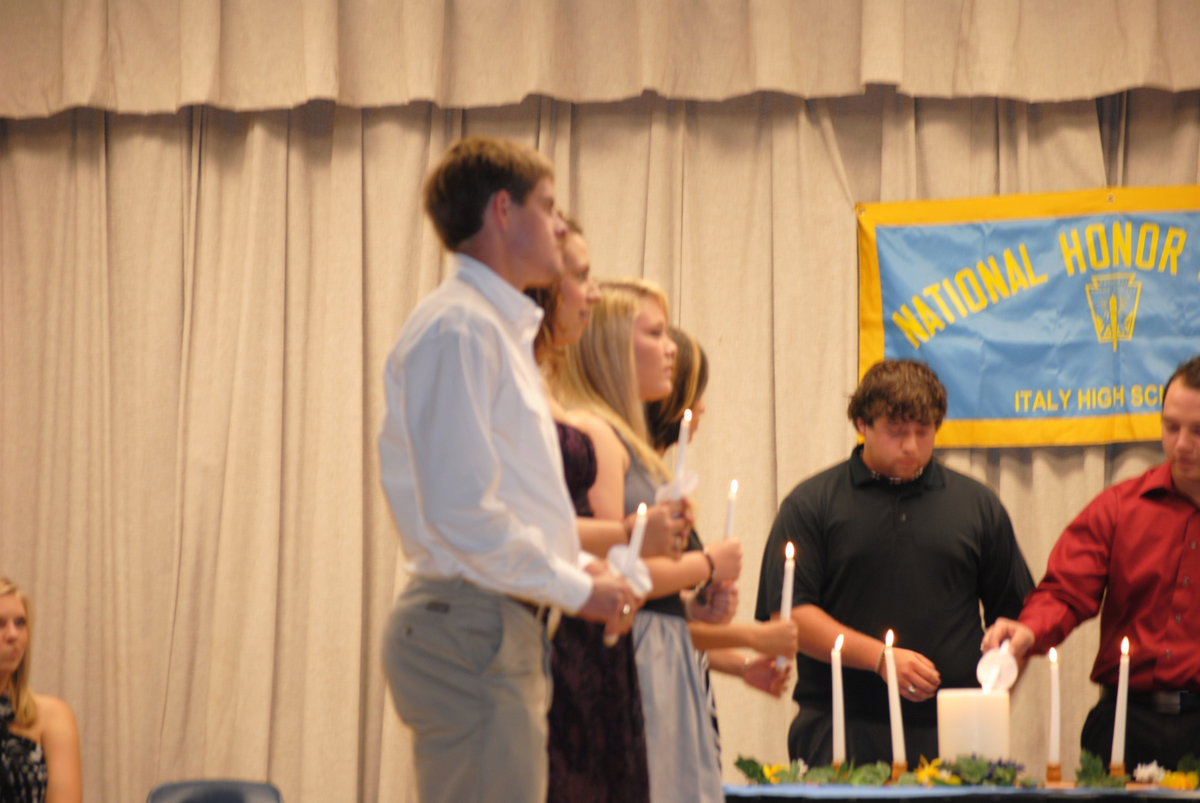 Image: The passing of the light — The existing officers offer the new inductees their positions of light.