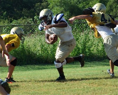 Image: Senio scampers — Gladiator quarterback Jasenio Anderson scampers during practice.