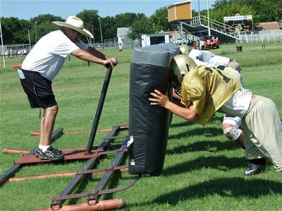 Image: Hold on, Coach! — Lineman coach Stephen Coleman holds on to the sled while the offensive lineman plow the back forty.