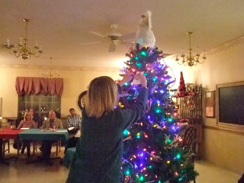 Image: Pat Pratt — Pat is hanging June Frame’s Angel on the tree.