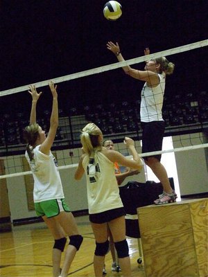 Image: Coach spikes — Coach Heather Richters simulates a spike to the Varsity defense as Kaitlyn Rossa and Sierra Harris get set.