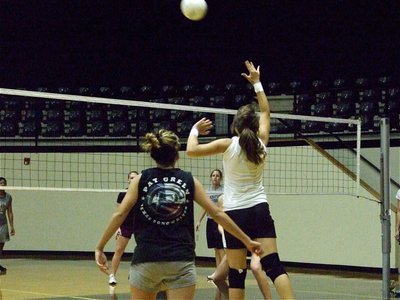 Image: Up and over — Brianna Perry keeps the volley going against the J.V. squad.