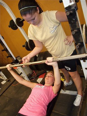 Image: Weight a minute — It safe to say the Taylor Turner is on her own while doing the bench press as Paige Westbrook spots Taylor with just one finger and one hand behind her back.