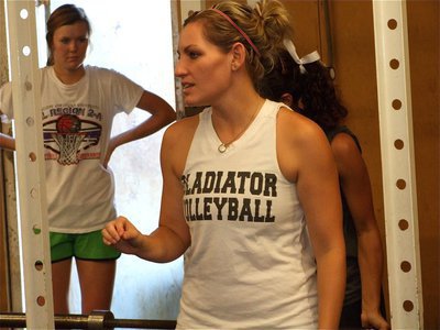 Image: Coach instructs — Head Volleyball Coach Heather Richters discusses proper form during the Lady Gladiators’ weight lifting session.