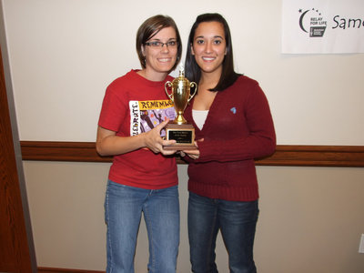 Image: Traveling Trophy winners — Jenna Chambers and Kasey Montgomery proudly display their trophy for raising the most money for the month of October.