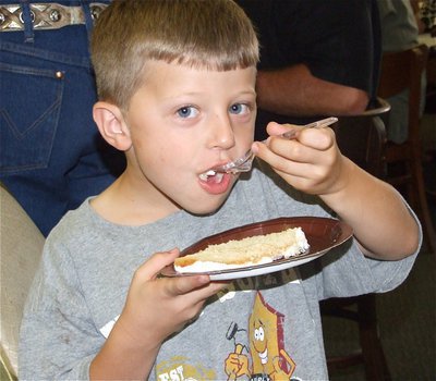Image: Cade has cake too — Cade Sims enjoys his slice of cake without embarrassment.
