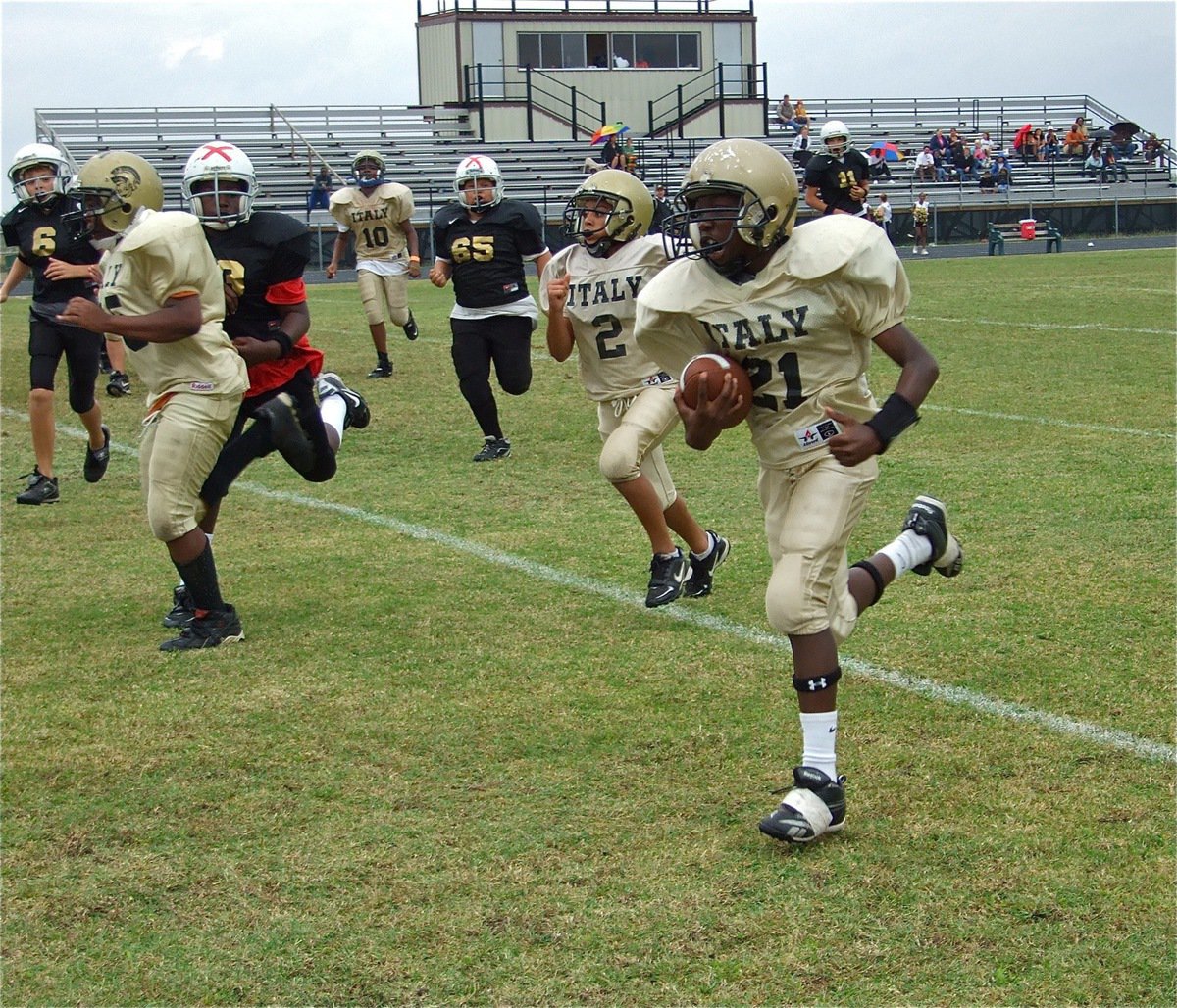 Image: Chasston Wilson(21) gets the IYAA A-Team in the endzone first — Italy’s Kenneth Norwood(25), Tylan Wallace(2) and Jarvis Harris(10) help lead the way for Chasston Wilson(21) as Wilson sprints into the endzone to give the IYAA A-Team a 7-0 halftime lead over Hubbard.