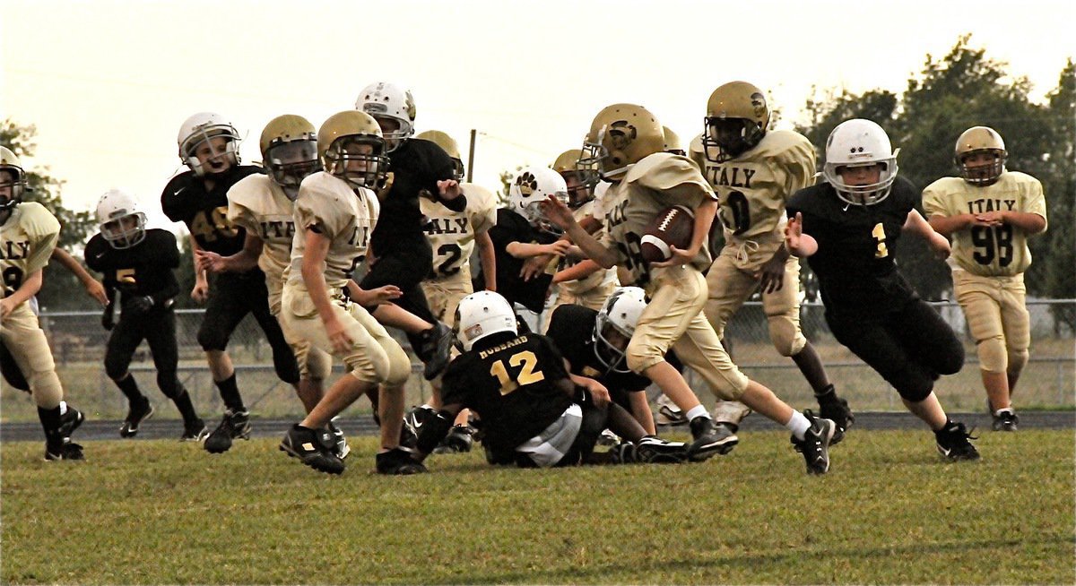 Image: Cash goes fast — IYAA B-Team runner Garrett Cash(28) avoids a Jaguar tackler in the backfield and then breaks outside.