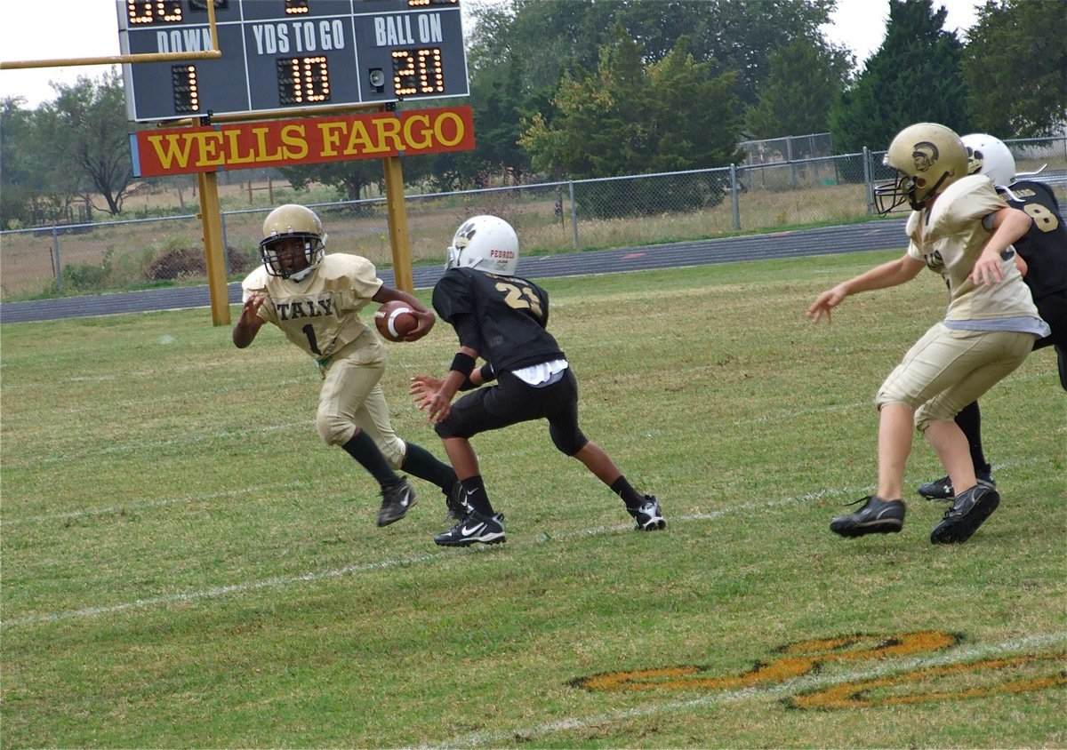 Image: Gaining ground — Italy’s Kendrick Norwood(1) receives a block from Clay Riddle(31) and heads for the sideline.