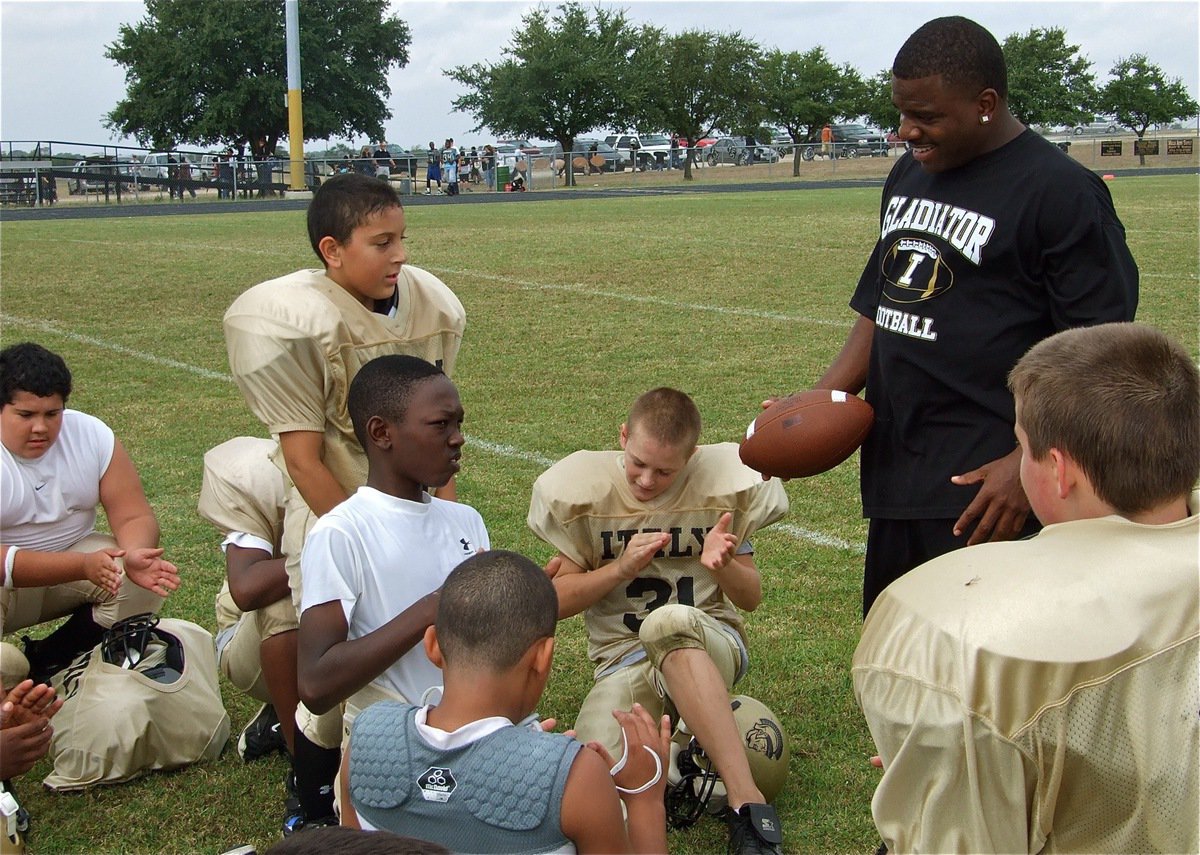 Image: Game ball — Italy’s A-Team assistant coach Edwin Wallace presents Andrew Barron with an honorary game ball for his efforts on defense which included two interceptions in the first half. Barron’s efforts preserved a 7-0 halftime lead for Italy and gave the A-Team the momentum they needed to defeat Hubbard 13-7.