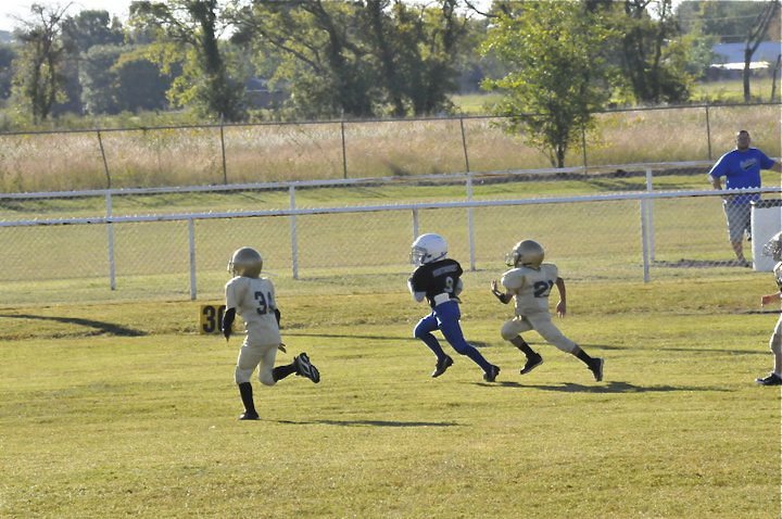 Image: Bulldog catchers — C-Team Gladiators Jaiden Barr(34) and Laveraneus Green(21) catch this runaway Bulldog before he can reach the endzone. The effort helped the C-Team Gladiators earn their first shutout of the season, 19-0.