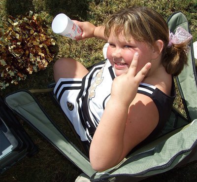 Image: Peace! — IYAA cheerleader Virginia Stephens has a coke and a smile during a break in the action.